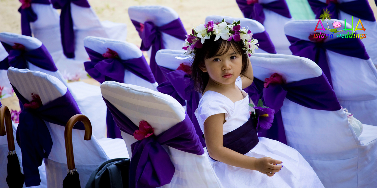 Purple sash color around the white chair cover with a flower girl